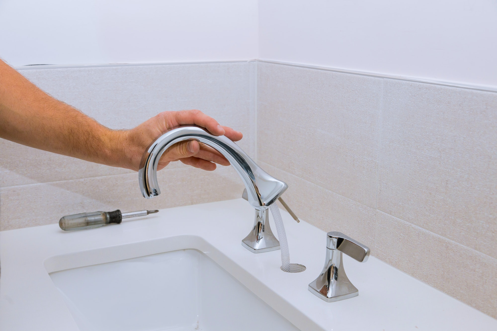 Repair service, assemble and install new faucet lies on the ceramic sink